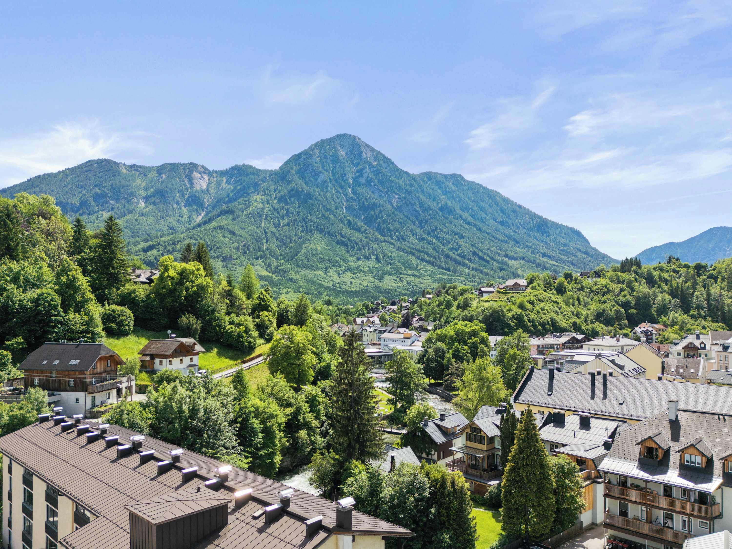 A mountainous landscape with residential buildings, some with balconies and solar panels.