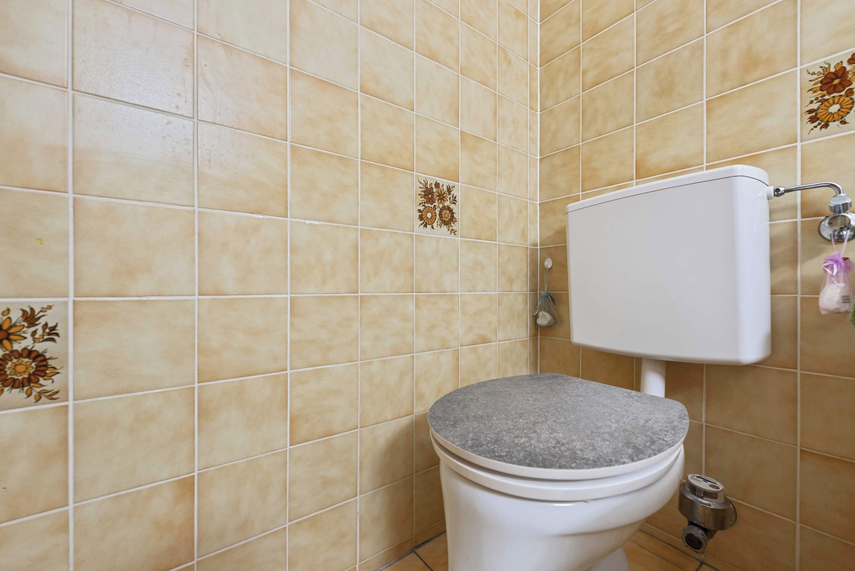Bagno con il water, pareti piastrellate e zona doccia.