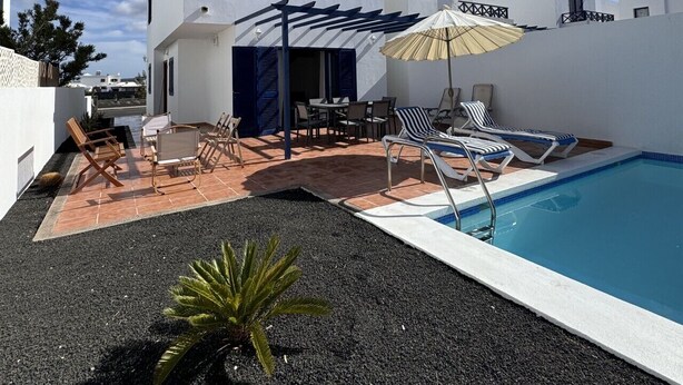 A modern building with a pool, outdoor seating, and a pergola. - Papagayo House, Playa Blanca (Playa Blanca)