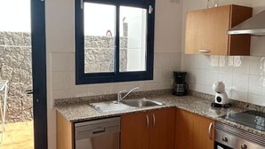 A compact kitchen with a dishwasher, a coffee maker, and a stove. - Papagayo House, Playa Blanca (Playa Blanca)