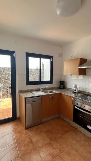 A compact kitchen with a dishwasher, a coffee maker, and a stove. - Papagayo House, Playa Blanca (Playa Blanca)