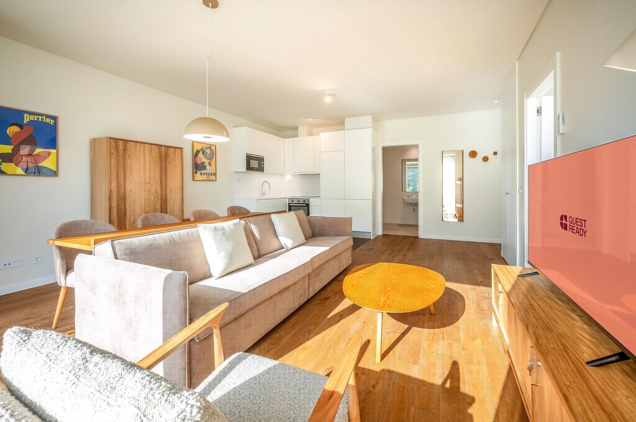 A modern living room with a sofa, coffee table, and a TV.