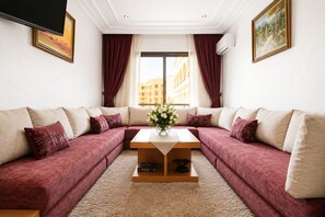 Ein Wohnzimmer mit einer Sofagarnitur, einem Couchtisch und einem Bild an der Wand.