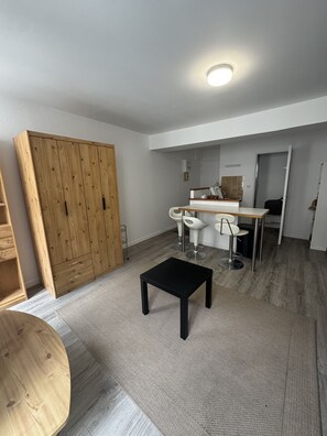 Ein stilvoller Wohnraum mit einem Holzschrank, einem schwarzen Tisch und einem weißen Stuhl.