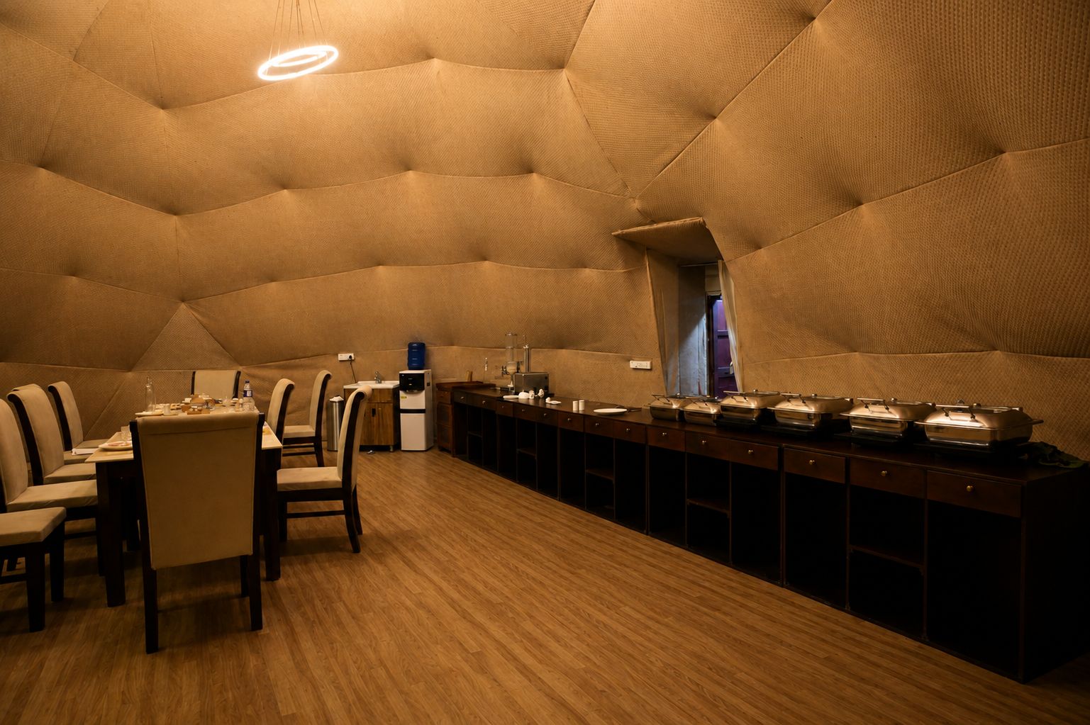 A dining area with a long table, chairs, and a buffet setup.