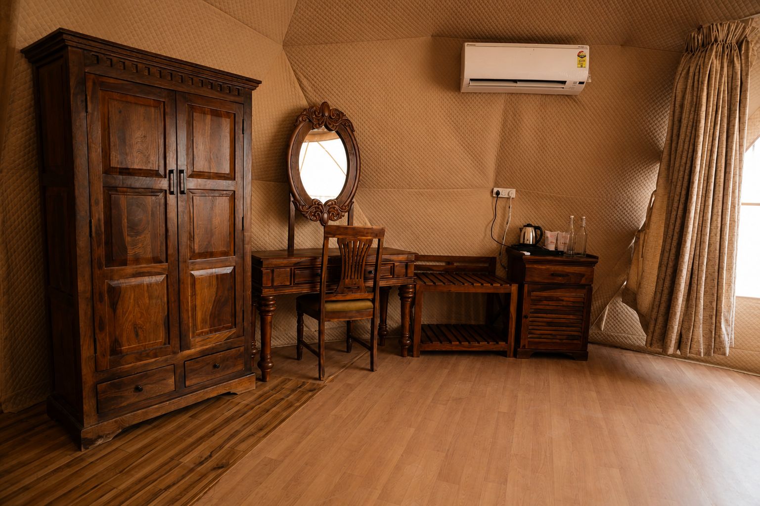 Een kamer met een houten garderobe, een bureau met stoel, een spiegel en een raam met gordijnen.