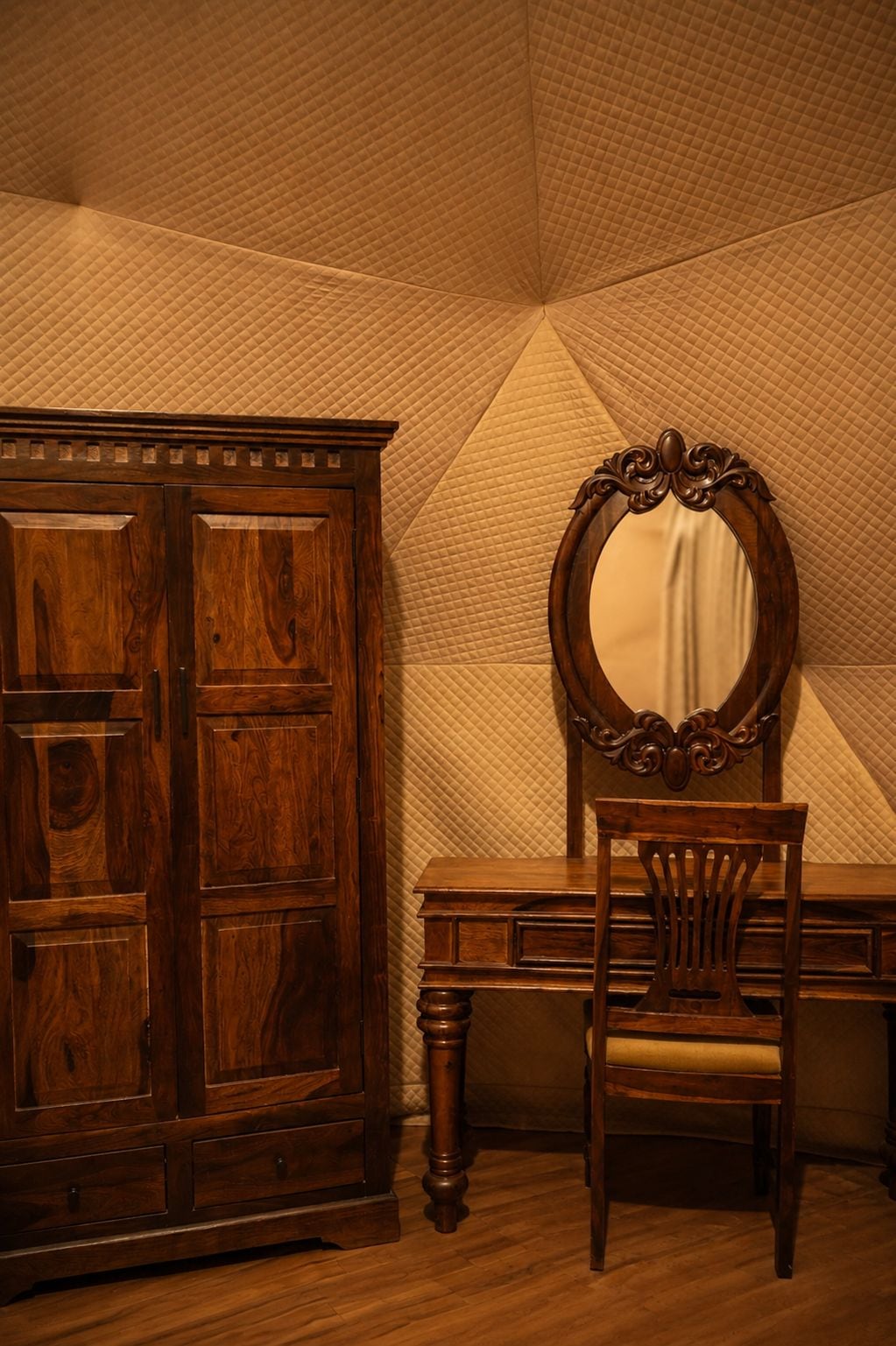 A room with a wooden wardrobe, a mirror, and a chair.