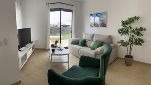 A living room with a sofa, a green armchair, a coffee table, a TV, and a potted plant. - Casa Aday, Playa Blanca (Playa Blanca)