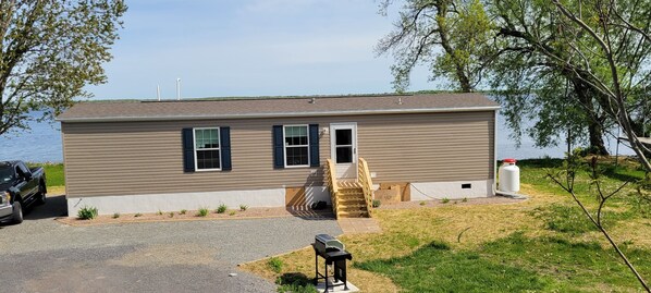 Ein Bungalow mit Veranda, Garage und kleinem Vorgarten.