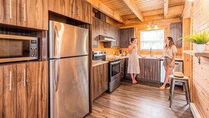 A modern kitchen with wooden cabinets, stainless steel appliances, and a central island.