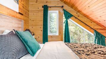 A bedroom with a bed, curtains, and a window.