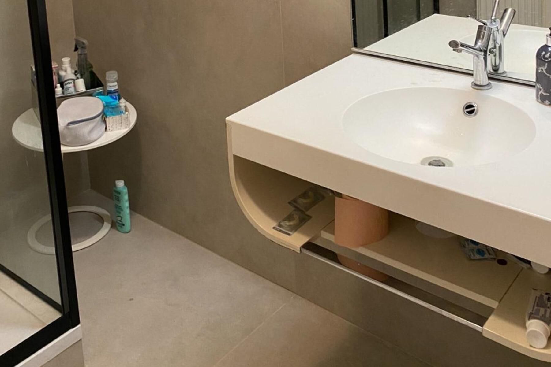 A bathroom with a sink, mirror, and toiletries.
