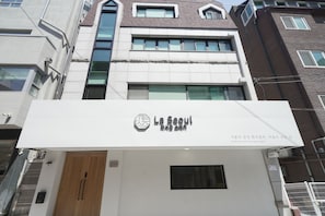 Ein Gebäude mit einem Schild, auf dem 'La Seoul' steht, und einer Holztür.
