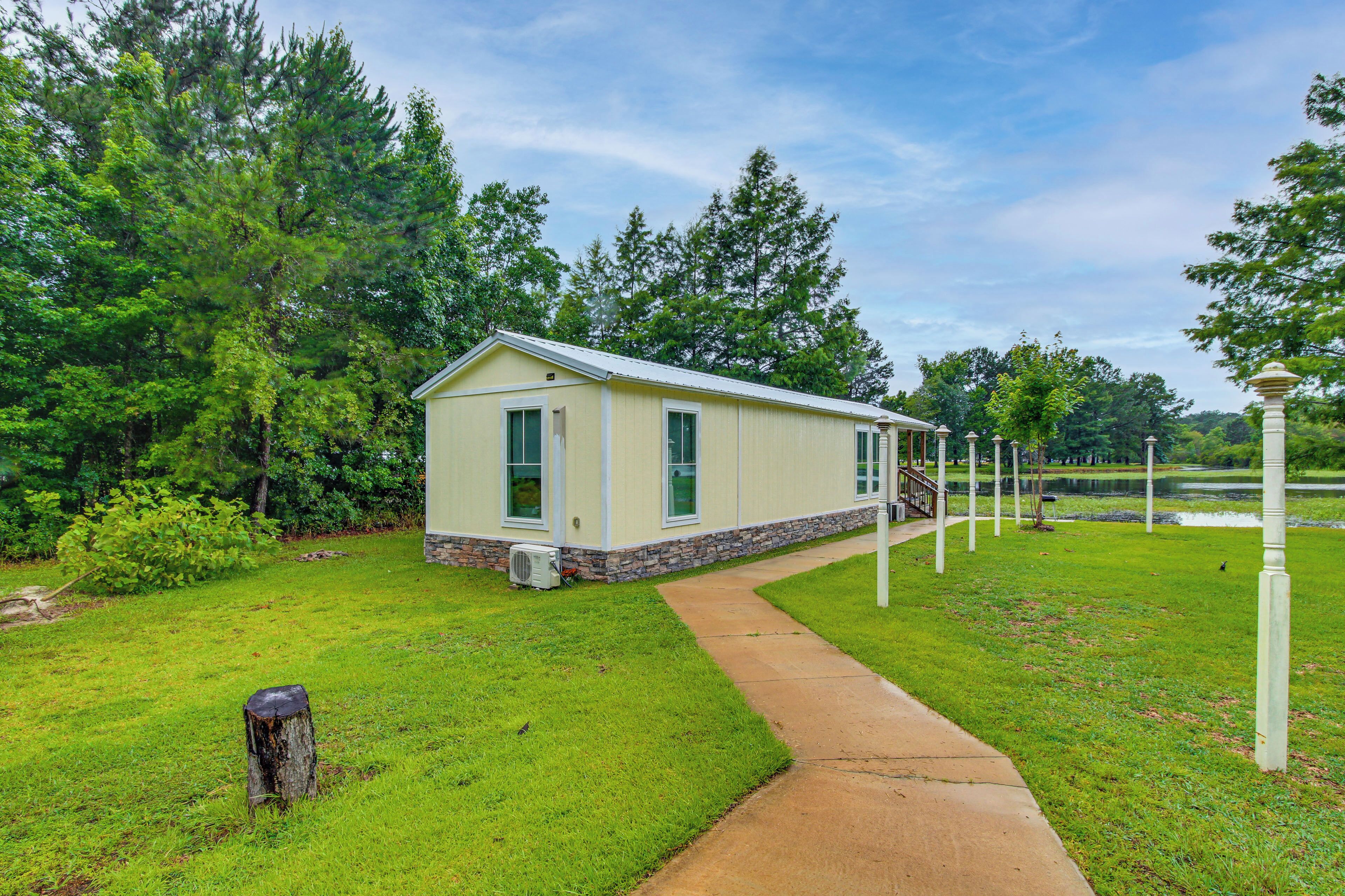 A single-story building with a sloped roof, a stone foundation, and a small porch.