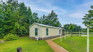 A single-story building with a sloped roof, a stone foundation, and a small porch. - Waterfront Couples Retreat w/ Views in Andalusia! (Andalusia)