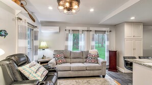 A living room with a sofa, a coffee table, a lamp, and a view of the outdoors. - Waterfront Couples Retreat w/ Views in Andalusia! (Andalusia)