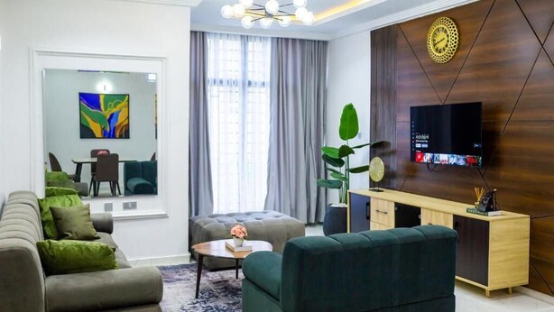 A modern living room with a sofa, a coffee table, a TV, and a wooden cabinet.