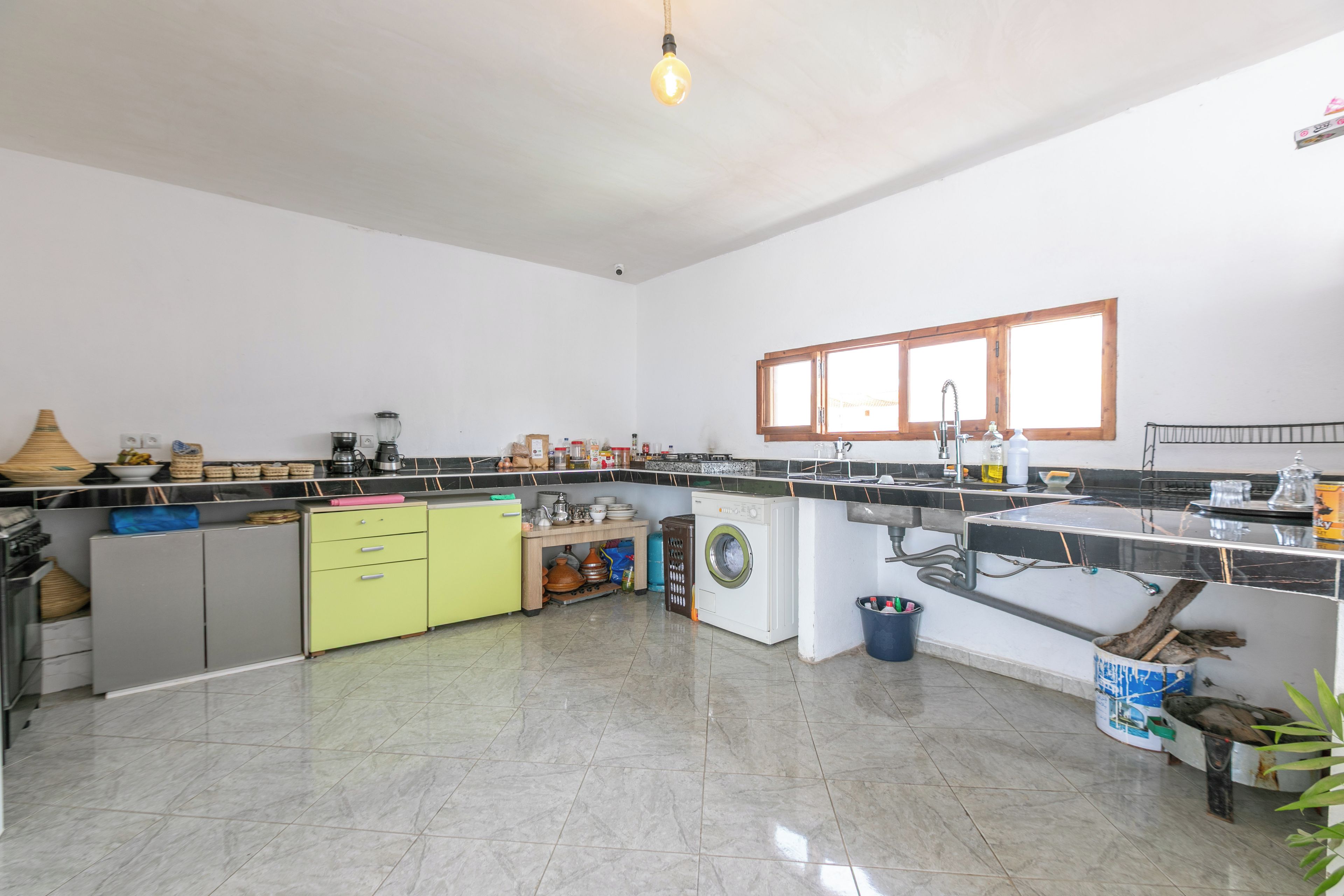 Cozinha espaçosa com ilha central, máquina de lavar e pia.
