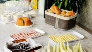 A table with various food items including bread, fruits, and a cake.