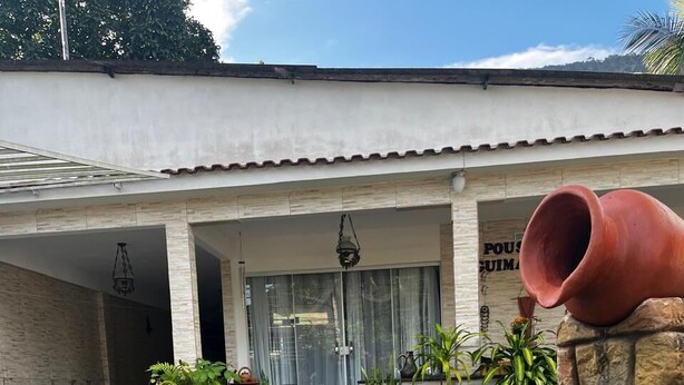 A house with a front yard, a small fountain, and potted plants.
