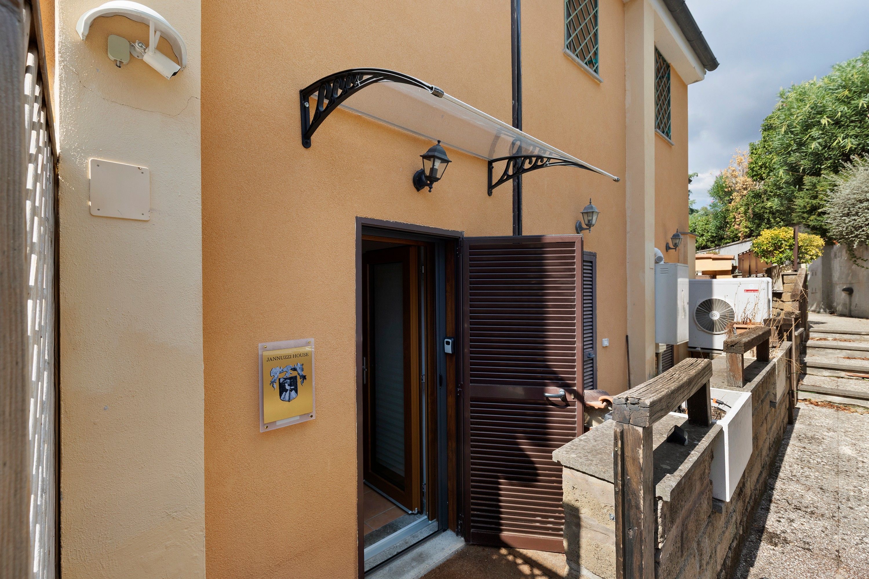 Un bâtiment avec une porte marron, un petit hall d’entrée et une enseigne indiquant « MAISON JANNUZZI ».