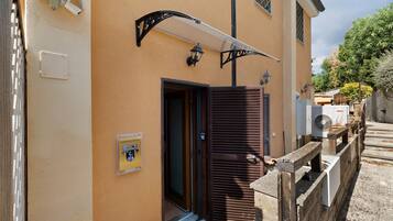 Un bâtiment avec une porte marron, un petit hall d’entrée et une enseigne indiquant « MAISON JANNUZZI ».