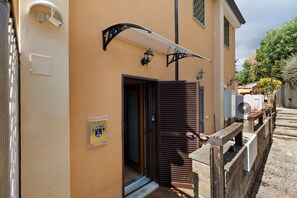 Un bâtiment avec une porte marron, un petit hall d’entrée et une enseigne indiquant « MAISON JANNUZZI ».