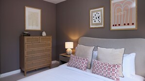 A bedroom with a bed, a dresser, a nightstand with a lamp, and three framed artworks on the wall. - Oak & Earth Isle of Dogs Apartment (London)