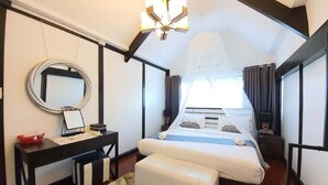 A bedroom with a bed, bedside table, mirror, and a hanging light fixture. - PAPA Beach Pool Villas Pattaya (Bang Lamung District)