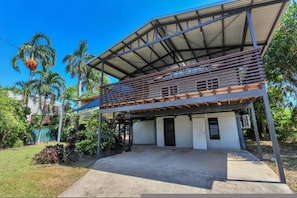 A two-story building with a covered patio area, a concrete driveway, and surrounding greenery. - Zen Outback Pool - Garden - Balcony - Parking (Darwin)