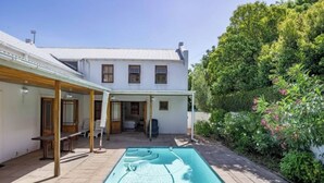 A two-story building with a swimming pool in the backyard. - Dream Holiday Home in the Heart of Franschhoek (Franschhoek)