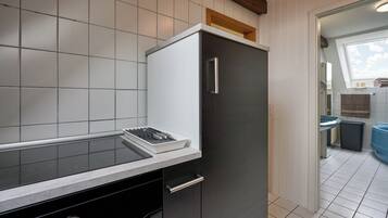 Een koffiezetapparaat/waterkoker, een koelkast, een magnetron, een oven