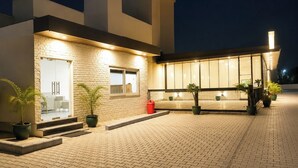 Un edificio moderno con fachada de ladrillo, ventanas amplias y plantas en macetas.