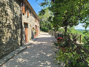 Ein Steinhaus mit einem Kiesweg, der zu einem Holzzaun führt.