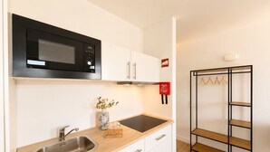 Une cuisine moderne équipée d’un four à micro-ondes, d’un évier et d’un plan de travail en bois.
