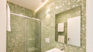 Une salle de bain avec une douche à parois de verre, un lavabo blanc et un miroir au-dessus du lavabo.