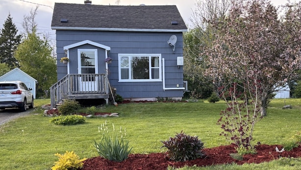 A two-story house with a front porch, a driveway, and a well-maintained lawn. - Tata Tides Getaway (Tatamagouche)