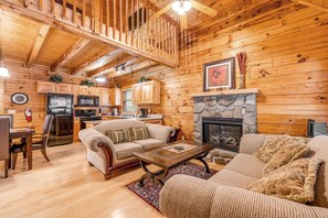 A log cabin interior with a living room, kitchen, and dining area. - 1 Mile to Pigeon Forge・Charming Log Cabin・Hot Tub (Pigeon Forge)