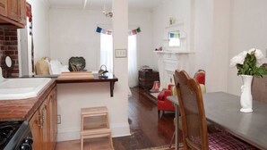 A kitchen with wooden cabinets, a countertop, a sink, and a dining area with a table and chairs.