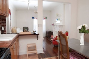 A kitchen with wooden cabinets, a countertop, a sink, and a dining area with a table and chairs. - Maison de sirènes 2, Bohemian, ecclectic apartment (Brooklyn)