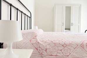 A bedroom with a bed, a white nightstand with a lamp, and a white wardrobe. - SE283 – Senigallia, four-room apartment with private parking space and balcony (Senigallia)