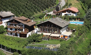 Un edificio grande con varios balcones, piscina y paneles solares.