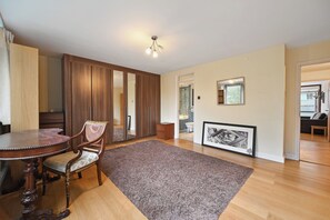 Una habitación con una mesa de comedor de madera, una silla, un espejo grande y un cuadro en la pared.