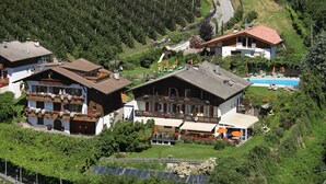 Ein großes Gebäude mit mehreren Balkonen, einem Schwimmbad und Solaranlagen.