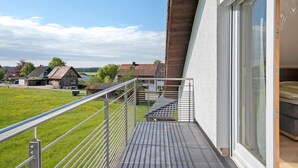 A balcony with a metal railing, a view of houses, and a door leading to a room. - Dog-friendly, modern holiday apartments with terrace, 2 balconies and Wi-Fi (Bräunlingen)