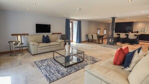 A modern living room with a sofa, coffee table, and a fireplace. - Dam House Barn (Settle)