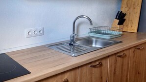 A kitchen with a stainless steel sink, wooden cabinets, a knife block, and a power outlet. - A very nice and cozy vacation rental for 10 people, with a private pool and garden. (Mostar)