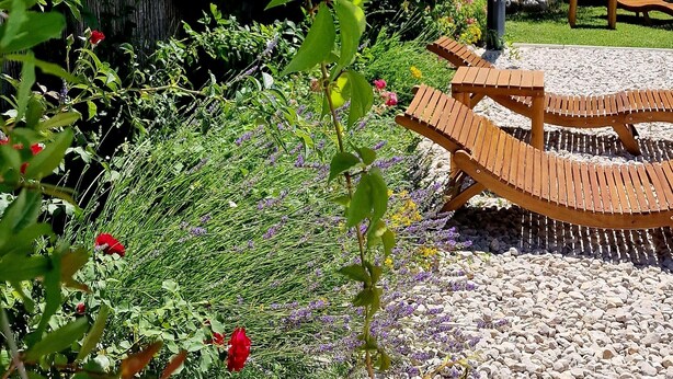A garden with a wooden bench, a table, and a view of mountains. - A very nice and cozy vacation rental for 10 people, with a private pool and garden. (Mostar)