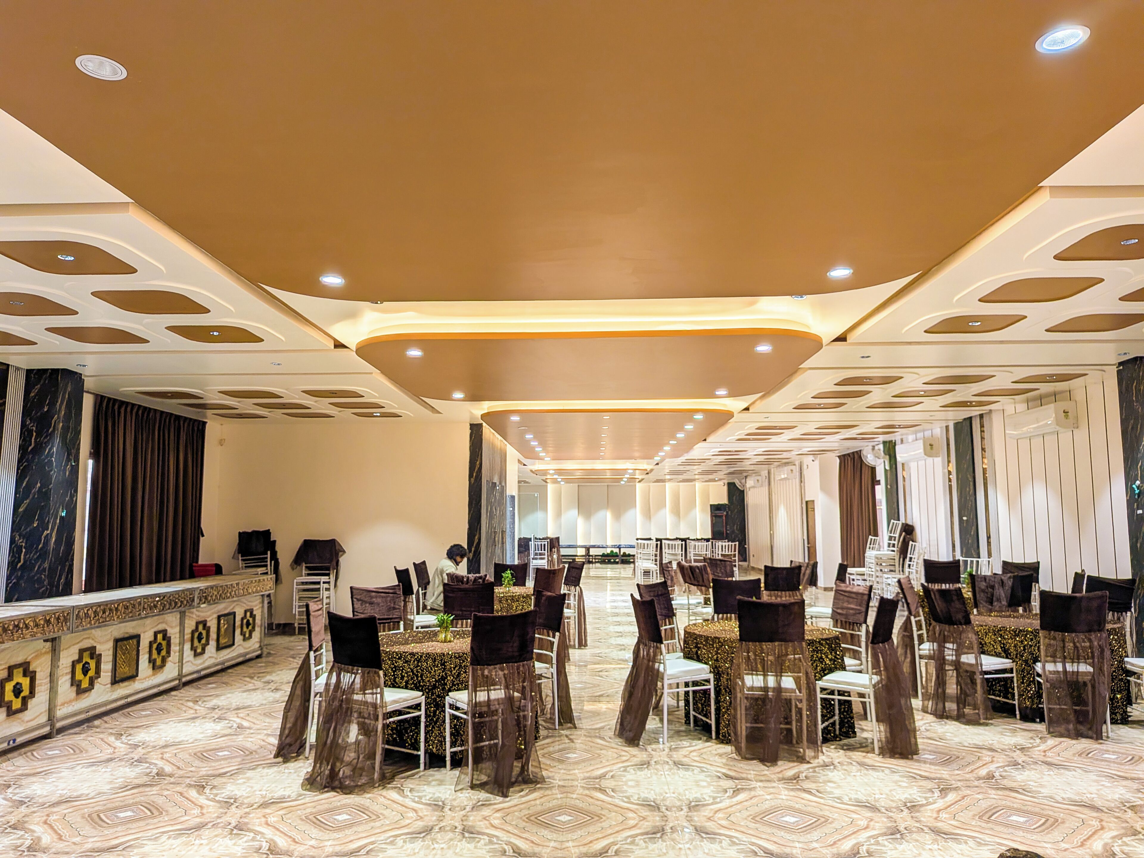 A banquet hall with a long table, chairs, and a decorative ceiling.