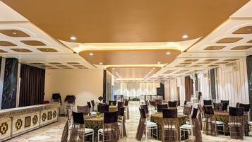 A banquet hall with a long table, chairs, and a decorative ceiling.